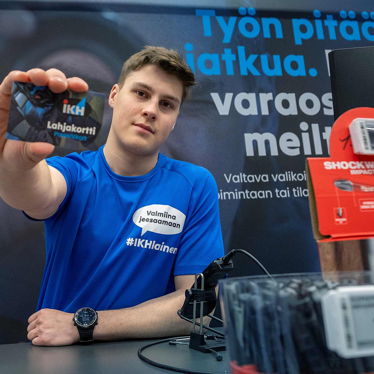 IKH-myymälässä myyjä kädessään IKH-lahjakortti